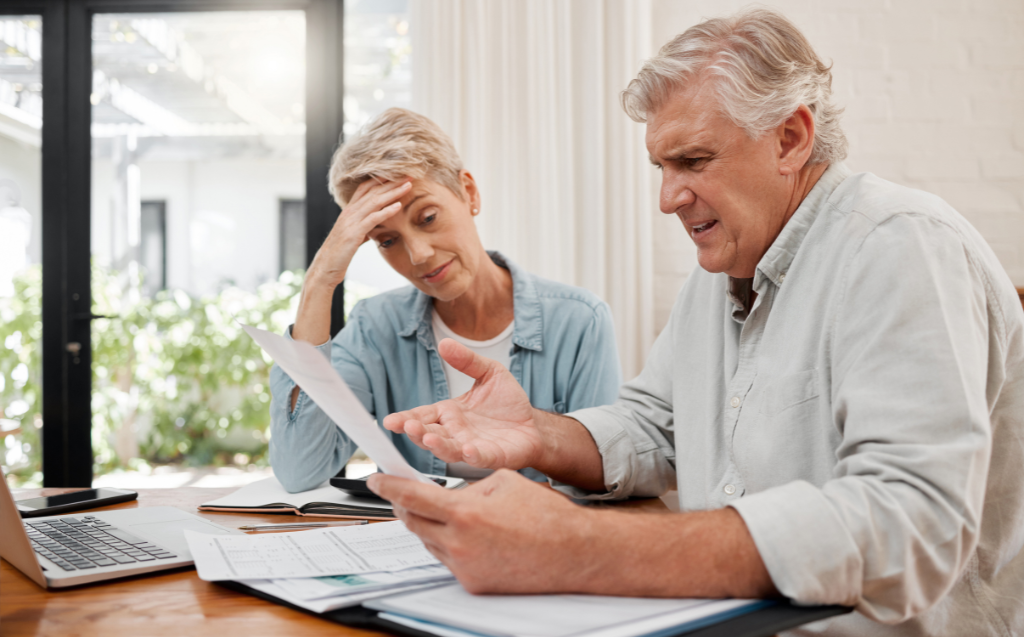 Sad retirement couple, finance debt and anxiety in financial planning, mortgage home loan and paper bills.
